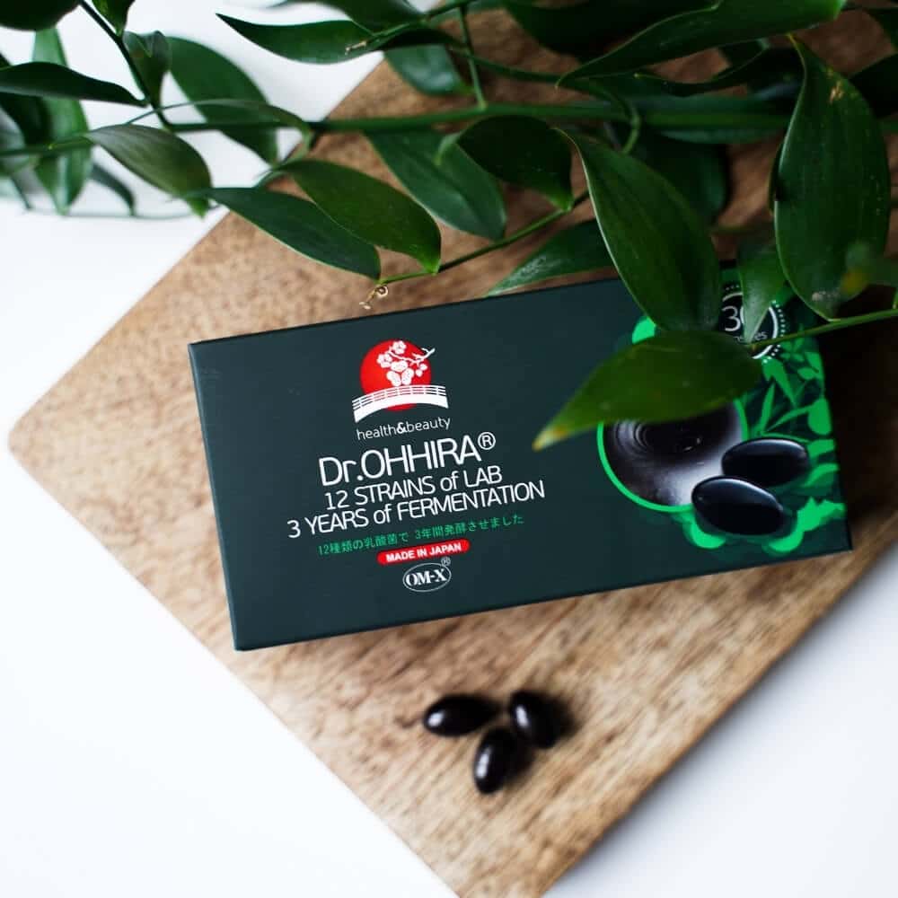 Dr.OHHIRA® STANDARD -maitohappobakteerikapseleita ja pakkaus puisella alustalla.